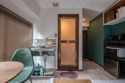 a small kitchen with a table and a refrigerator at #16 -\u65b0\u9ad8\u5186\u5bfa \u30e1\u30be\u30f3\u30e2\u30ea\u30bf- Studio in Tokyo