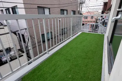 a balcony with green grass on a building at #16 -\u65b0\u9ad8\u5186\u5bfa \u30e1\u30be\u30f3\u30e2\u30ea\u30bf- Studio in Tokyo