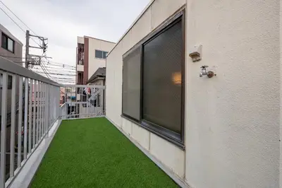 a balcony with green grass on the side of a building at #16 -\u65b0\u9ad8\u5186\u5bfa \u30e1\u30be\u30f3\u30e2\u30ea\u30bf- Studio in Tokyo