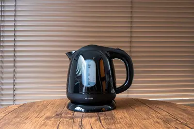 a black tea kettle sitting on a wooden table at #16 -\u65b0\u9ad8\u5186\u5bfa \u30e1\u30be\u30f3\u30e2\u30ea\u30bf- Studio in Tokyo