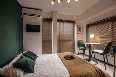 a bedroom with a bed and a table and chairs at #16 -\u65b0\u9ad8\u5186\u5bfa \u30e1\u30be\u30f3\u30e2\u30ea\u30bf- Studio in Tokyo