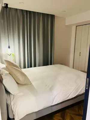a bed with white sheets and pillows in a room at YFhouse\u6c60\u888bikebukuro-Direct to Ginza, Tokyo Dome, and the Harry Potter Studio Tour Tokyo in Tokyo