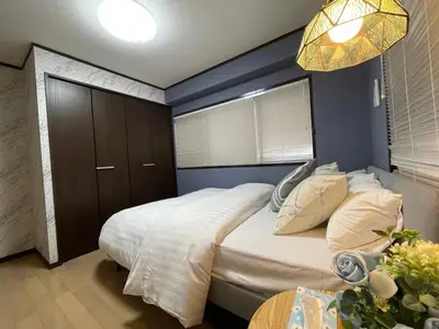 a bedroom with a large bed with a blue wall at YFhouse\u6c60\u888bikebukuro-Direct to Ginza, Tokyo Dome, and the Harry Potter Studio Tour Tokyo in Tokyo