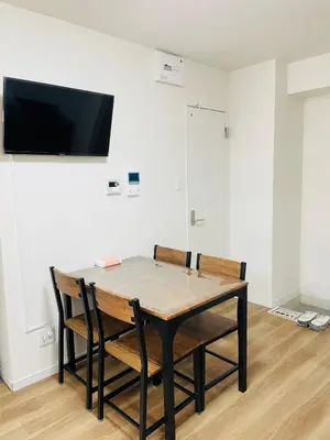 a dining room table with two chairs and a flat screen tv at T-Hotel \u6d45\u8349 in Tokyo