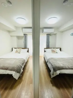 two beds in a room with two mirrors at T-Hotel \u6d45\u8349 in Tokyo