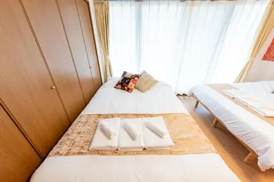 a small bedroom with two beds and a window at Joint Court Kameido in Tokyo
