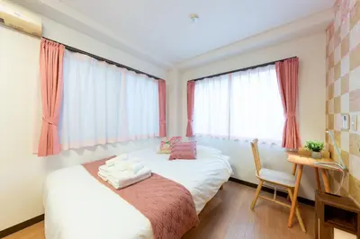 a bedroom with a bed with a chair and a desk at Joint Court Kameido in Tokyo