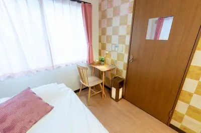 a bedroom with a bed and a table and a door at Joint Court Kameido in Tokyo
