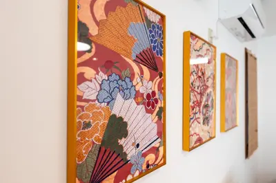 a group of paintings hanging on a wall at Joint Court Kameido in Tokyo