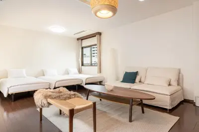 a living room with two white couches and a table at \u30ab\u30e1\u30ea\u30a2\u30d3\u30eb in Tokyo