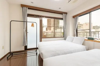 two beds in a room with a window at \u30ab\u30e1\u30ea\u30a2\u30d3\u30eb in Tokyo