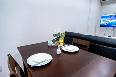 a dining room table with two white plates and a vase of oranges at Japanese style single-family house, three floors, 75 square meters, three bedrooms and one living room in Tokyo