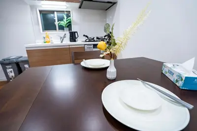 a dining room table with two white plates on it at Japanese style single-family house, three floors, 75 square meters, three bedrooms and one living room in Tokyo