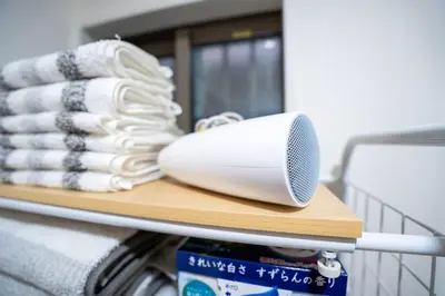 a white hair dryer sitting on a shelf with towels at Japanese style single-family house, three floors, 75 square meters, three bedrooms and one living room in Tokyo