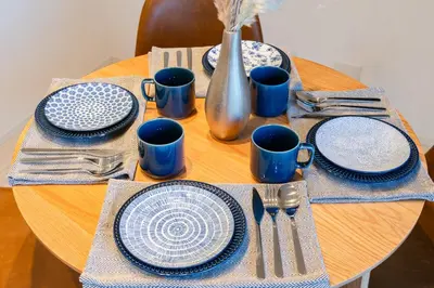 a wooden table with blue and white plates and utensils at Househotel EKODA 201 HE21 in Tokyo