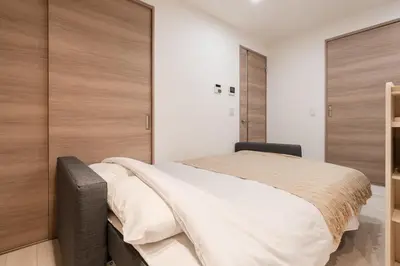 a bedroom with a large bed with wooden doors at Househotel EKODA 201 HE21 in Tokyo
