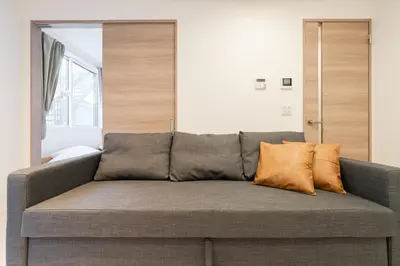 a couch with pillows on it in a room at Househotel EKODA 201 HE21 in Tokyo
