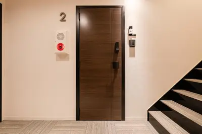 a wooden elevator door in a room with stairs at House hotel EKODA 202 HE22 in Tokyo