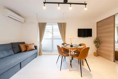 a living room with a blue couch and a table and chairs at House hotel EKODA 202 HE22 in Tokyo