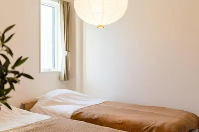 a bedroom with a bed and a window and a chandelier at House hotel EKODA 202 HE22 in Tokyo