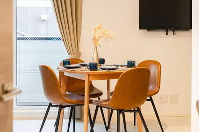 a dining room table with four chairs and a television at House hotel EKODA 202 HE22 in Tokyo