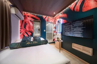 a bedroom with a bed with a painting on the wall at Hotel CARA \u5927\u4eba\u5c02\u7528Adult only hotel in Tokyo