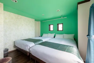 a bedroom with green walls and a large bed at \u6c60\u888b\u672c\u753a3,4\u968e in Tokyo
