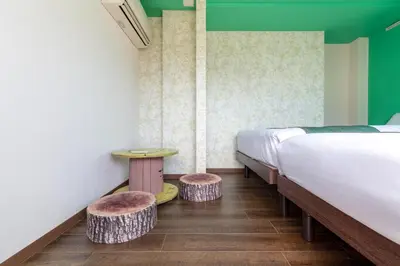 a bedroom with two beds and two stools at \u6c60\u888b\u672c\u753a3,4\u968e in Tokyo
