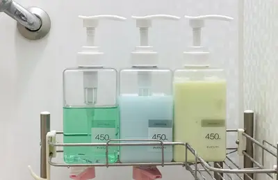 a rack with four bottles of liquid in a bathroom at \u6c60\u888b\u672c\u753a3,4\u968e in Tokyo