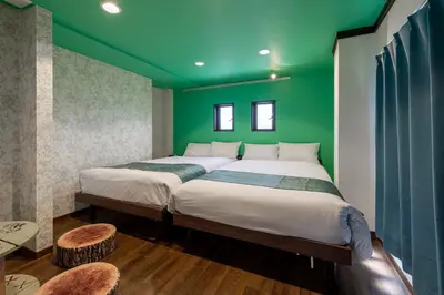 two beds in a room with green walls at \u6c60\u888b\u672c\u753a3,4\u968e in Tokyo