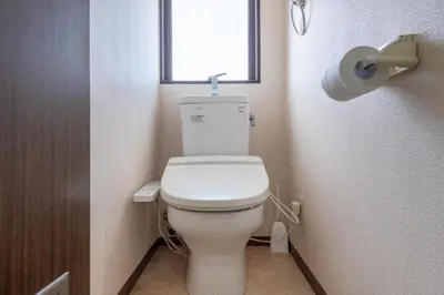 a bathroom with a toilet with a window at \u6c60\u888b\u672c\u753a3,4\u968e in Tokyo