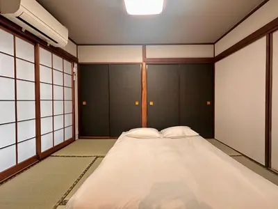 a large bed in a room with black walls at LoveAsakusaBigSpaceModernHome 浅草寺6分 浅草寺駅10分 2-8人 成田&羽田空港直通 in Tokyo