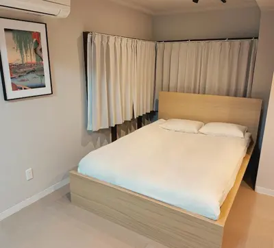a bedroom with a large bed with white sheets at LoveAsakusaBigSpaceModernHome 浅草寺6分 浅草寺駅10分 2-8人 成田&羽田空港直通 in Tokyo