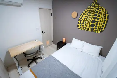 a bedroom with a white bed and a desk and a desk at \u65b0\u5bbf\u539f\u753a\u8cb8\u5207\u4e00\u8ed2\u5bb6 in Tokyo