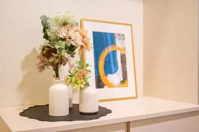 two white vases with flowers on a shelf at Yahiro Villa in Tokyo