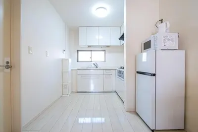 a kitchen with white appliances and a refrigerator at Yahiro Villa in Tokyo