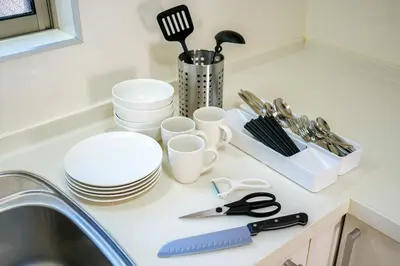a kitchen counter with plates and utensils and a sink at Yahiro Villa in Tokyo