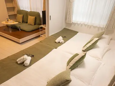 a bedroom with a large bed with pillows on it at \u685c\u306e\u5ddd50 \u6771\u4eac\u6674\u7a7a\u585410\u5206\u949f\u672c\u6240\u543e\u59bb\u6a4b\u99c55\u5206\u949f5\u4eba\u623f\u4e28 Tokyo skytree 10 mins Honjo Azumabashi 5 minutes5 people in Tokyo