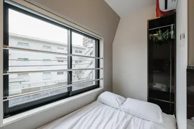 a bedroom with a large window and a bed at Mi-HOTEL QUALIA SHINJUKU in Tokyo