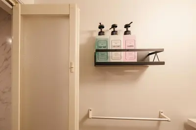a bathroom with two bottles of soap on a shelf at Mi-HOTEL QUALIA SHINJUKU in Tokyo