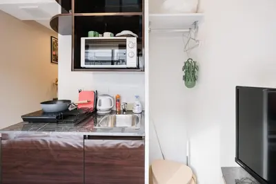 a small kitchen with a sink and a microwave at Mi-HOTEL HEARTS SHINJUKU in Tokyo