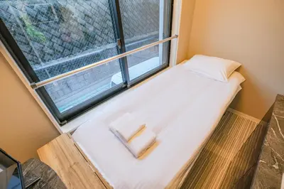 a bed in a room with a window at Mi-HOTEL HEARTS SHINJUKU in Tokyo