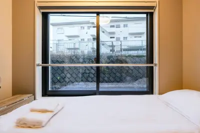 a bed in a room with a large window at Mi-HOTEL HEARTS SHINJUKU in Tokyo