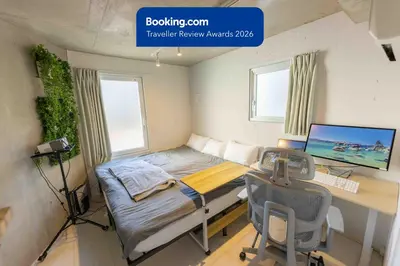 a bedroom with a bed and a desk with a computer at Fox & Fortune 4A -Nomad Stay- 3-min Walk, PS5, Apple Studio in Tokyo