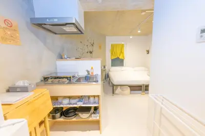 a kitchen with a sink and a room with a bed at Fox & Fortune 4A -Nomad Stay- 3-min Walk, PS5, Apple Studio in Tokyo