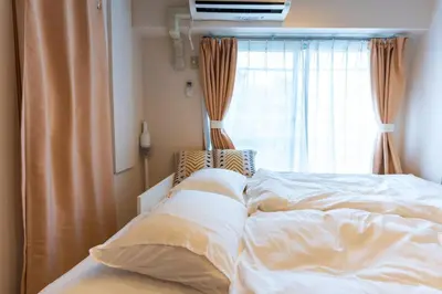 an unmade bed in a bedroom with a window at 25Yamanote JR line Takadanobaba sat 5mit Netflix watch!Up to 3 people! in Tokyo