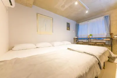 a bedroom with a large white bed with a window at Fox & Fortune 4B -New Near station Luggage storage Netflix- in Tokyo