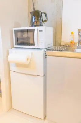 a microwave oven sitting on top of a refrigerator at Fox & Fortune 4B -New Near station Luggage storage Netflix- in Tokyo