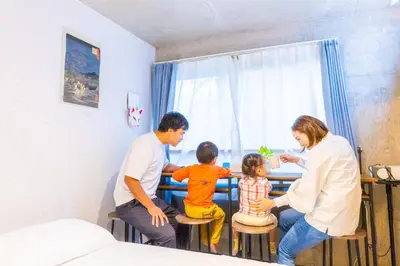 a family sitting on stools in a room at Fox & Fortune 4B -New Near station Luggage storage Netflix- in Tokyo