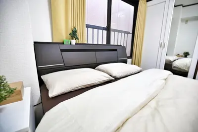 a bedroom with a bed with two pillows on it at Alice\u5c0f\u5c4b601 in Tokyo